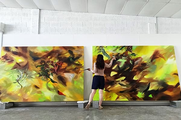 Molly Timmins painting large abstract landscapes in her studio