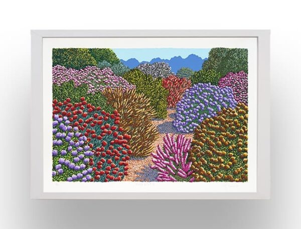 A framed painting of a garden path lined with colorful bushes and flowers, with green hills and blue mountains in the background.