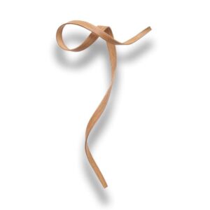 A single thin wooden strip is twisted into a loose, flowing ribbon shape on a white background, casting a soft shadow.