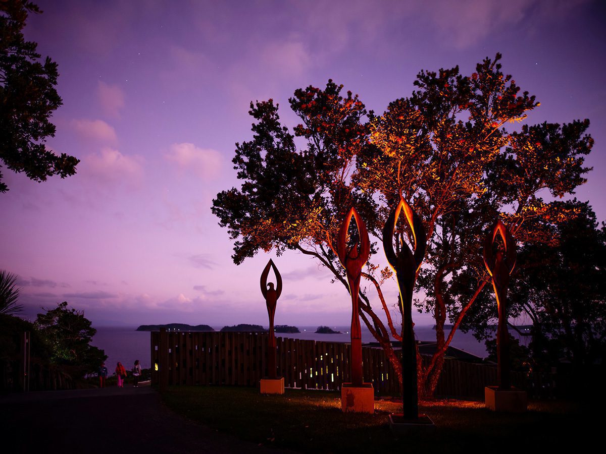 This stunning clifftop shot taken at dusk where the sky has turned pinky/purple and a couple of stars have just appeared is the backdrop to four large outdoor bird-like sculptures, which glow from the lighting below them, as do the trees behind them, while in the distance islands can be seen in the sea.